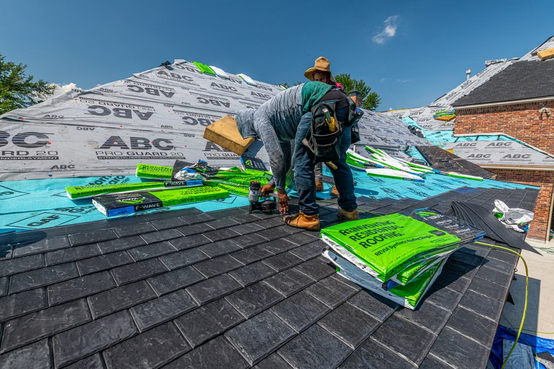 Roofing crew installing shingles on a residential roof